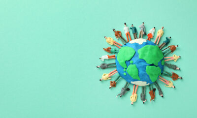 Illustration of a green and blue globe surrounded by small figures of people
